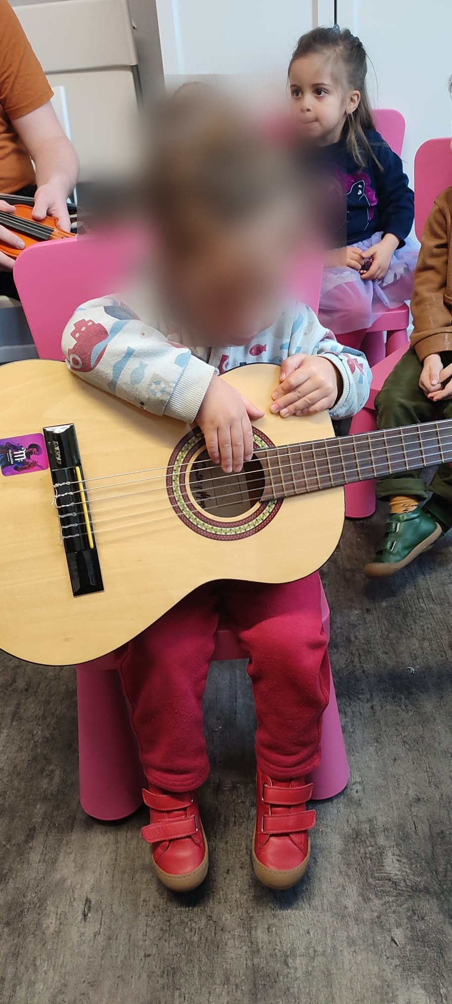 Un élève joue de la guitare pendant l'éveil musical